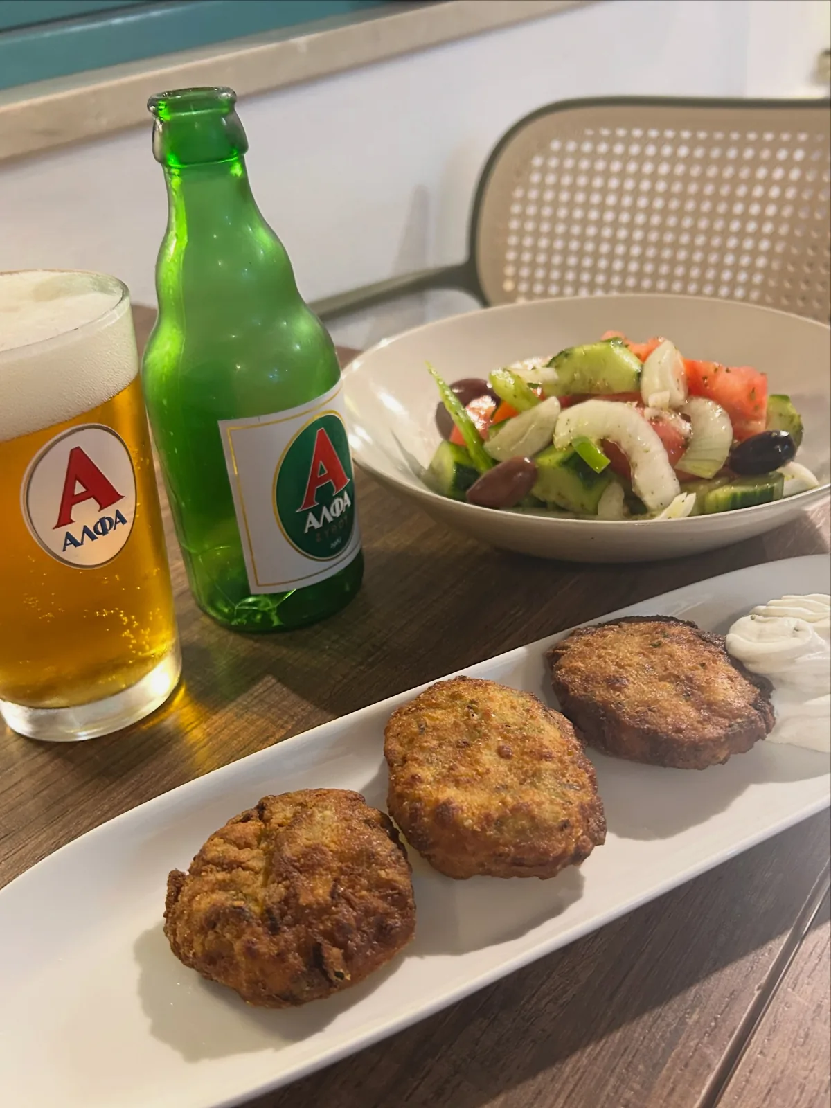 Kolokithokeftedes courgette fritters with tzatziki, a Greek salad and a cold Alfa beer